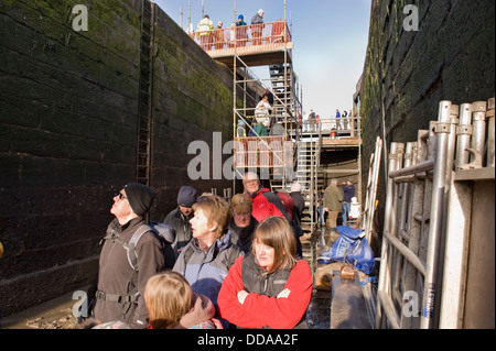 People inside a drained lock chamber, walking round & looking at renovation work - open day, Bingley's Five Rise Locks, West Yorkshire, England, UK. Stock Photo
