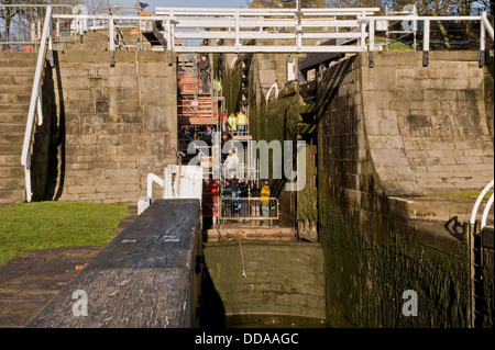 People inside a drained lock chamber, walking round & looking at renovation work - open day, Bingley's Five Rise Locks, West Yorkshire, England, UK. Stock Photo