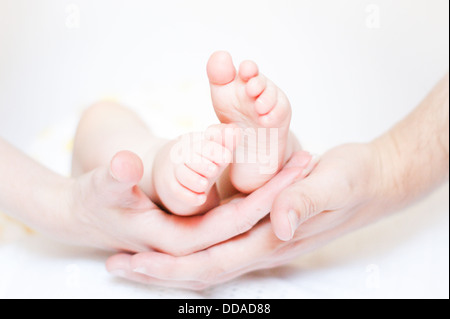 Baby feet held by parents hands Stock Photo