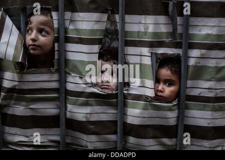 Gaza City, Gaza Strip. 29th Aug, 2013. Palestinian girls look behind a curtain at her family's home at al-Shati refugee camp. Credit:  Ashraf Amra/APA Images/ZUMAPRESS.com/Alamy Live News Stock Photo