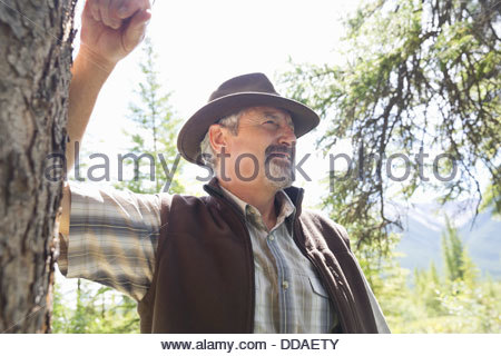 Smiling senior man standing in forest