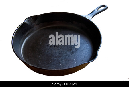 This is an old, black cast iron skillet, worn from many uses and age, isolated on a white background. Stock Photo