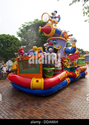 The water parade at Disneyland Hong Kong.  Disney characters travel along main street spraying water and dancing Stock Photo