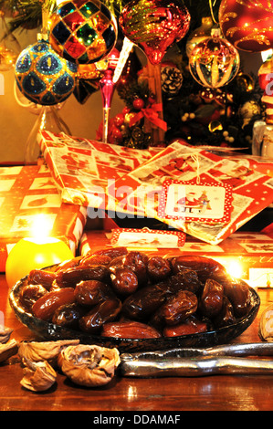 Dates in a shallow glass dish with Christmas presents under tree to the rear, England, UK, Western Europe. Stock Photo