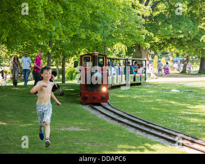 Miniature  train operating in Buxton Pavilion gardens for tourists and children pleasure rides Stock Photo