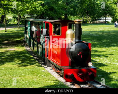 Miniature  train operating in Buxton Pavilion gardens for tourists and children pleasure rides Stock Photo