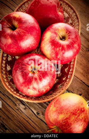 Fresh organic ripe apple fruits on old wooden table with canvas tablecloth. Image in vintage style Stock Photo