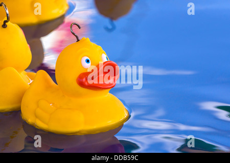 A yellow plastic duck awaits its turn to be hooked on a funfair stall on Bournemouth Pier. Stock Photo