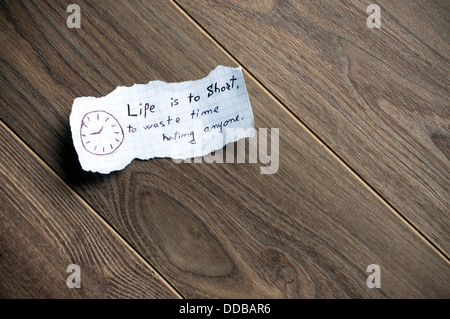 Motivational message,written on piece of paper, on a wood background. Space for uour text. Stock Photo