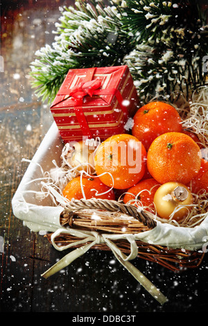 Mandarins in basket with Gift and Christmas tree branch Stock Photo