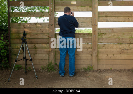 Bird watching and other wildlife observation. A bird watcher viewing through a screen at Attenborough Nature Reserve, Nottinghamshire, England, UK Stock Photo