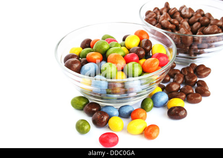 Colorful candies with raisins and peanuts in vases isolated on white background. Stock Photo