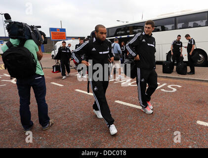 Cardiff, UK. Wednesday 28 August 2013  Pictured: Ashley Richards (C) and Ben Davies (R) arriving at Cardiff Airport.  Re: Swansea City FC players and staff en route for their UEFA Europa League, play off round, 2nd leg, against Petrolul Ploiesti in Romania. © D Legakis/Alamy Live News Stock Photo