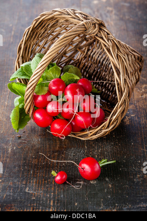 Fresh garden radish in wicker basket on wooden background Stock Photo