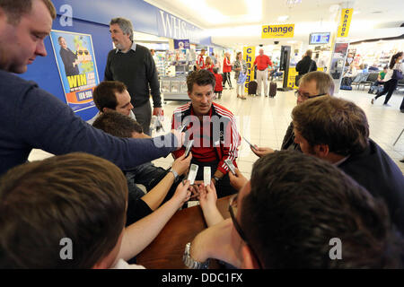 Cardiff, UK. Wednesday 28 August 2013  Pictured: Michael Laudrup (C) interviewed by members of the press at Cardiff Airport.  Re: Swansea City FC players and staff en route for their UEFA Europa League, play off round, 2nd leg, against Petrolul Ploiesti in Romania. © D Legakis/Alamy Live News Stock Photo