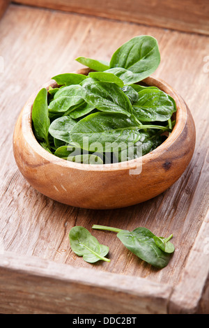 Young spinach in wooden bowl Stock Photo