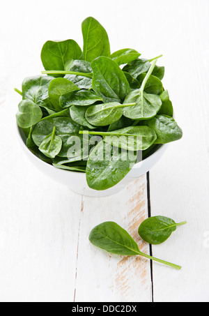 Young spinach in white bowl Stock Photo