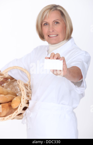 Female bakery worker displaying card Stock Photo