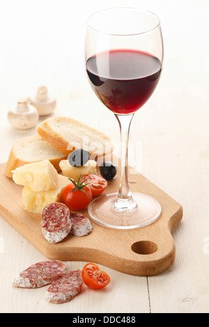 Cheese and Fruits Assortment on Cutting Board with Red, White Wine on  Wooden Background. Stock Photo by annapustynnikova