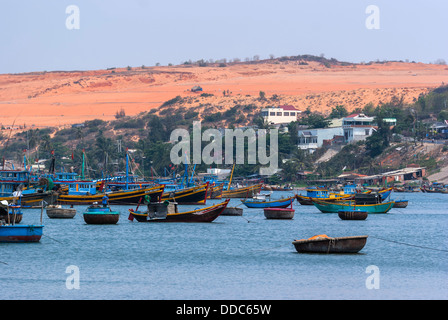 The dunes tower over the sea with its many fishing vessels. Stock Photo