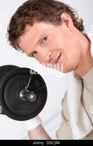 Man lifting dumbbells to improve his physique Stock Photo