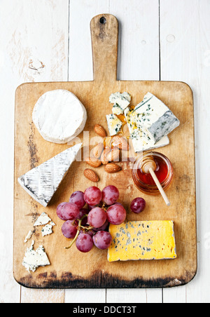 Assortment of various types of cheese on wooden board Stock Photo