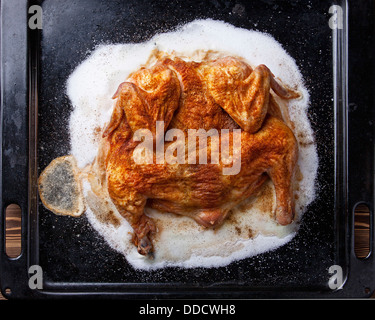 Whole roasted chicken with salt on black background Stock Photo