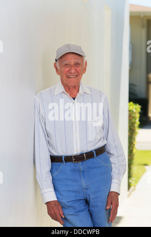 Senior man smiling relaxing in a doorway Stock Photo