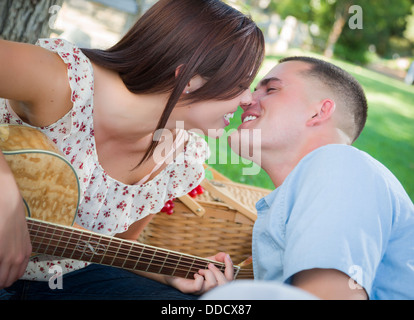 https://l450v.alamy.com/450v/ddcx87/affectionate-mixed-race-couple-with-guitar-kissing-in-the-park-ddcx87.jpg