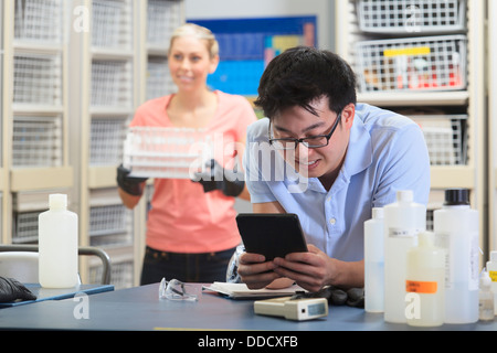 Engineering student using a tablet to record data in chemistry laboratory Stock Photo