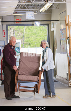 Senior couple moving furniture in a warehouse Stock Photo