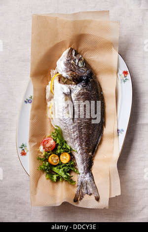 Baked fish with lemon and salad Stock Photo