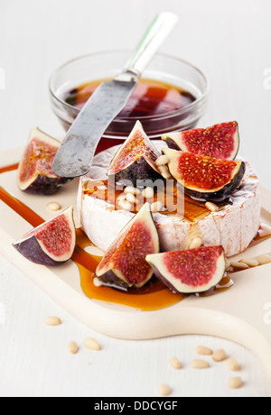 Cheese, figs and honey on light background Stock Photo