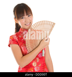 Asian woman with Chinese traditional dress cheongsam or qipao holding Chinese fan. Chinese new year concept, female model isolated on white background. Stock Photo