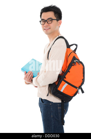 Handsome Asian adult student in casual wear with school bag carrying text books standing isolated on white background. Asian male model. Stock Photo