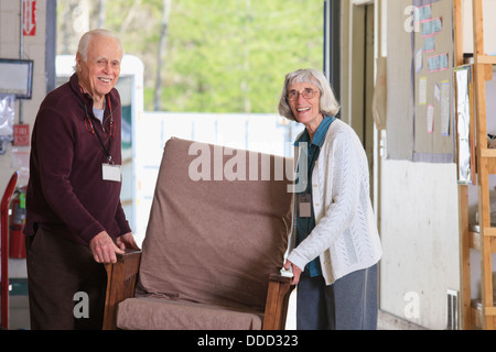Senior couple moving furniture in a warehouse Stock Photo