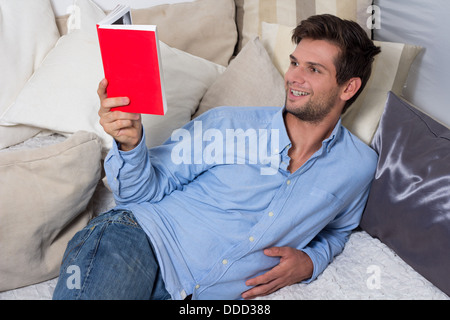Young Brunette Man in Blue Shirt Reading A Book Stock Photo