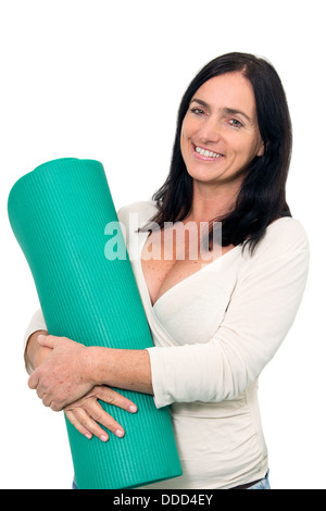 Dark haired Woman with an exercise matt in front of isolated background Stock Photo
