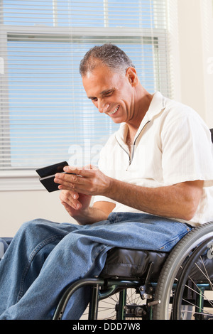Man with spinal cord injury in wheelchair using a smart phone Stock Photo