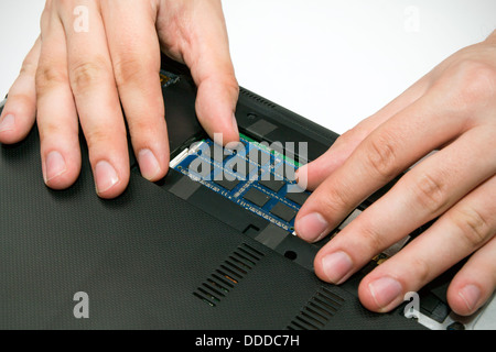 Man installing memory. Laptop RAM upgrade Stock Photo