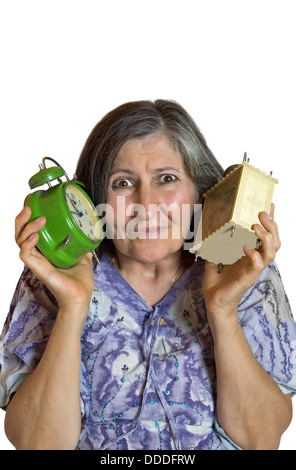 Portrait of shocked woman with two alarm clock over white background. Stock Photo