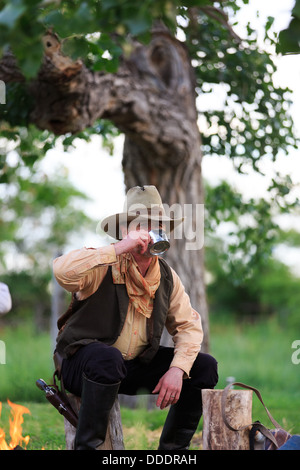 A cowboy preparing and eating breakfast at his campfire Stock Photo