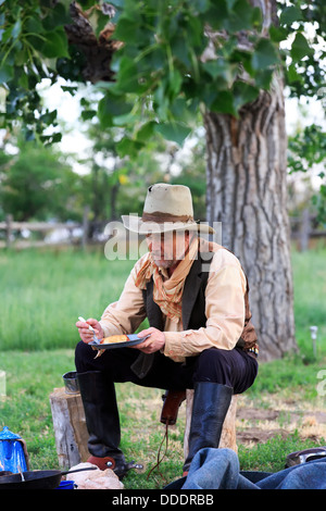 A cowboy preparing and eating breakfast at his campfire Stock Photo