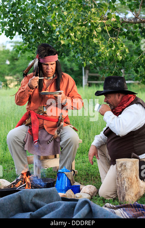 A cowboy and an Indian preparing and sharing breakfast Stock Photo