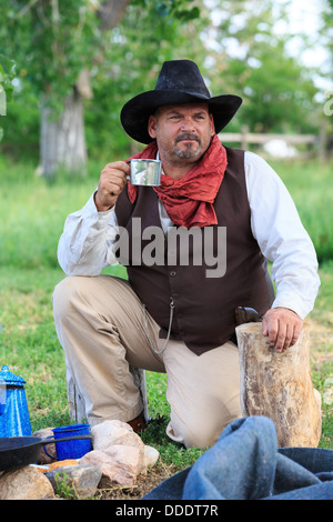 A cowboy preparing and eating breakfast at his campfire Stock Photo