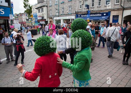 Round, circular, green head gear, topiary leafy artificial wigs, head planter worn by street performers in Kendal, Cumbria, UK. Aug 2013.   Mintfest, Kendal's International Festival of Street Arts,  The Potheads by Let’s Circus, outside Fat Face shop, a Lakes Alive weekend event in the Lake District which featured some of the very best from across the world who performed , contemporary dance, circus, comedy, music, quirky group outdoors in the streets. Stock Photo