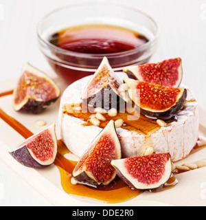Cheese, figs and honey on light background Stock Photo