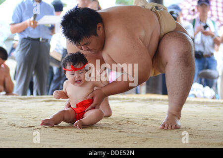 Wrestlers and babies take part in a sumo event at Matsuo Taisha Shrine in Kyoto, Japan. Stock Photo