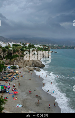 Beach La Caletilla, in the white village of Nerja, with approaching thunderstorm. Andalusia, Malaga, Spain.