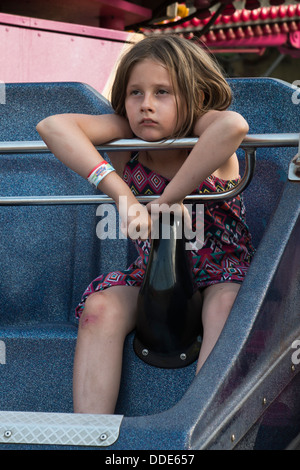 Model released image of a tired young girl on a ride at Southend on Sea, Essex. Stock Photo